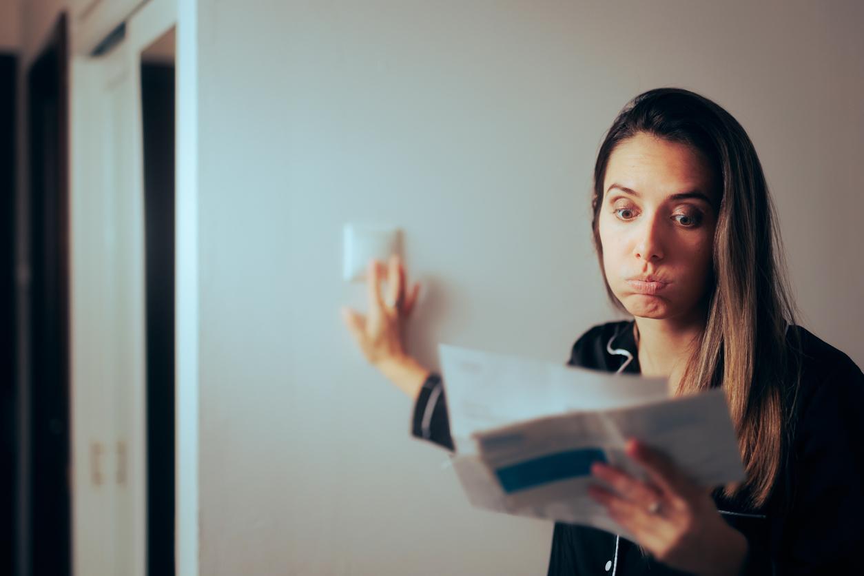 Woman Checking Electricity Bill Turning out the Lights at Home