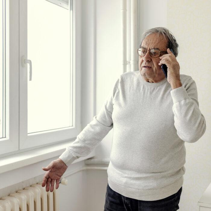 Man calls the repair service due to a problem with the cold radiator.