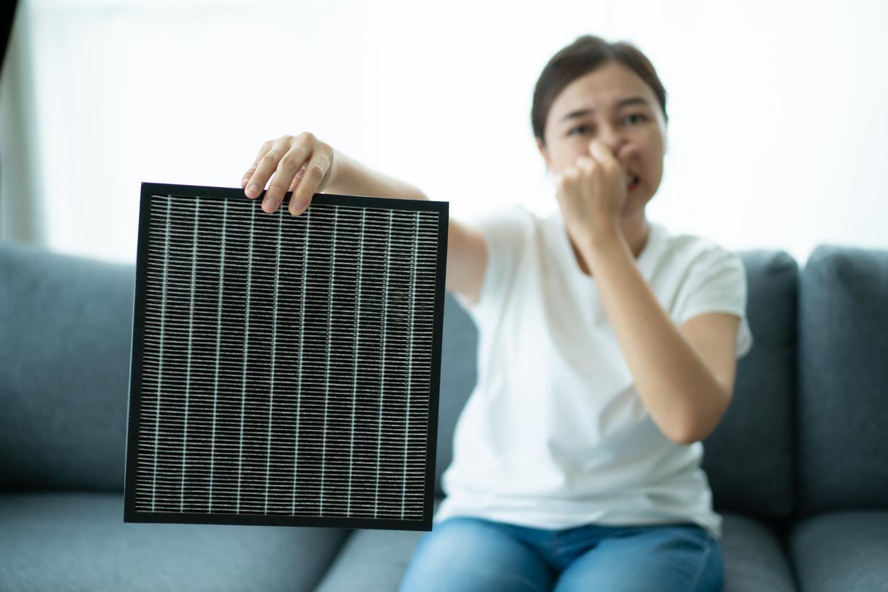 Woman replacing air purifier filter.