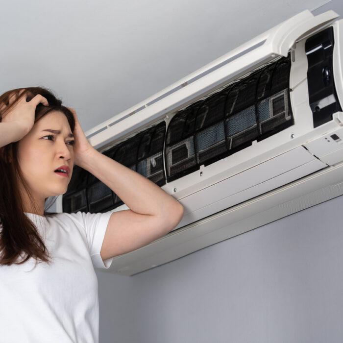 stressed woman has problem with the air conditioner at home