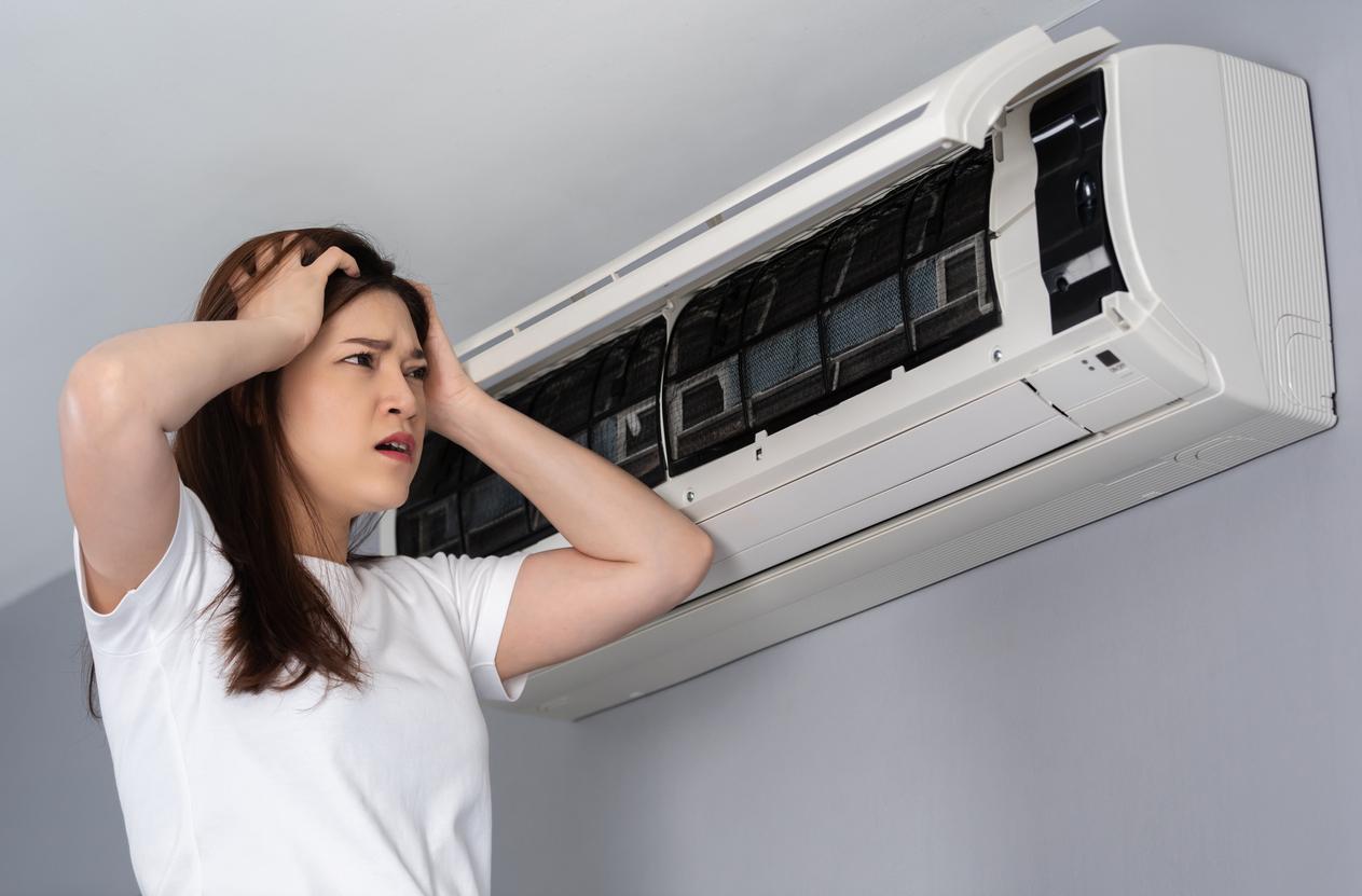 stressed woman has problem with the air conditioner at home