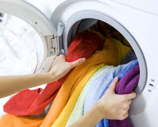 woman taking color clothes from washing machine