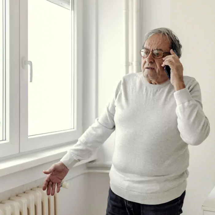 Man calls the repair service due to a problem with the cold radiator.