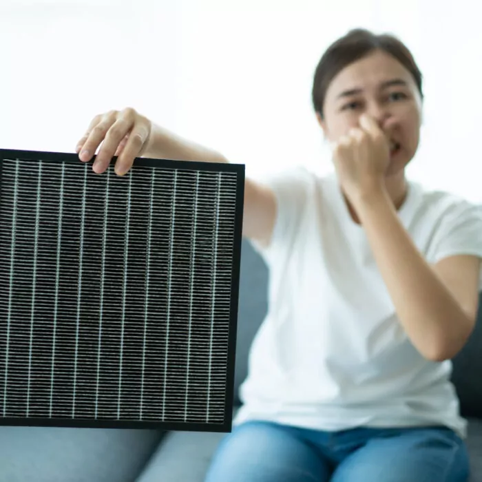 Woman replacing air purifier filter.